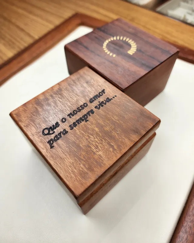 Caixas de madeira da Ouro e Terra, uma com frase gravada na tampa
